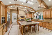 14 _ 24 Cosso Court _ Kitchen with a large island, copper sink, wooden cabinetry, and open views of the dining area