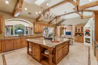 15 _ 24 Cosso Court _ Kitchen with a granite island, wooden cabinetry, stainless steel appliances, and adjacent dining area