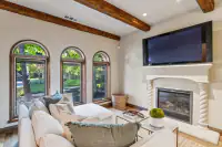 48 _ 24 Cosso Court _ Family Room with fireplace, wall-mounted TV, and arched windows