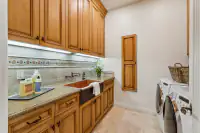 44 _ 24 Cosso Court _ Laundry room with farmhouse sink and wooden cabinetry