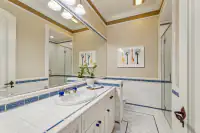 38 _ 24 Cosso Court _ Tiled vanity with blue accents and glass-enclosed shower