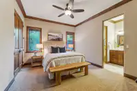 51 _ 24 Cosso Court _ Bedroom with wooden bench, ceiling fan, and ensuite bathroom
