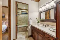52 _ 24 Cosso Court _ Bath with wood vanity, large mirror, and tiled shower